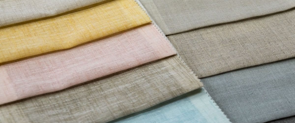 Campioni di tessuti in lino di vari colori, con il bordo tagliato a zig-zag